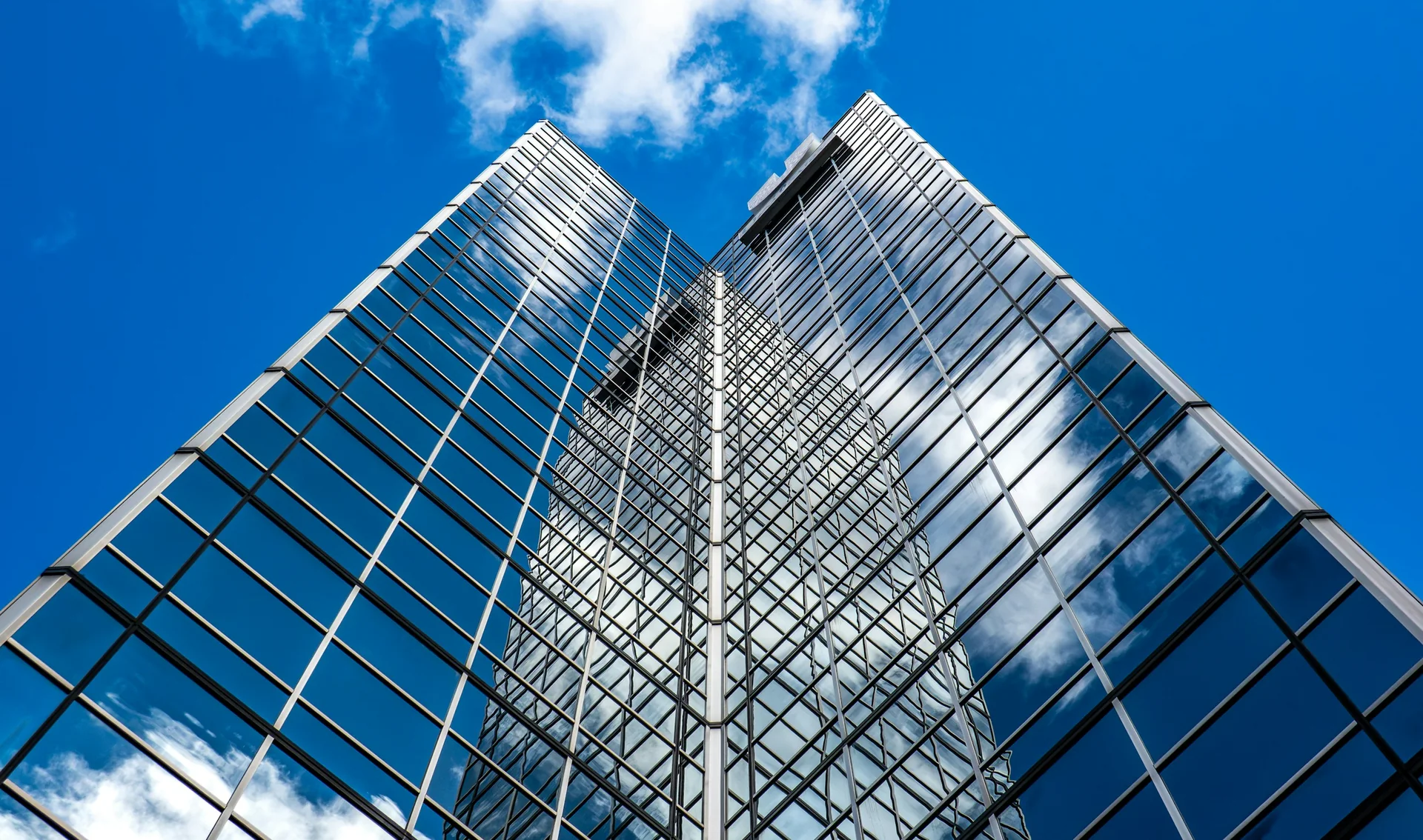 Glass corporate office tower against a blue sky