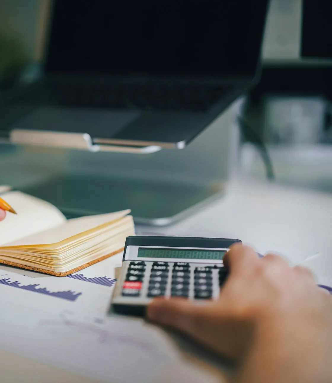 Calculating figures beside a ledger notebook