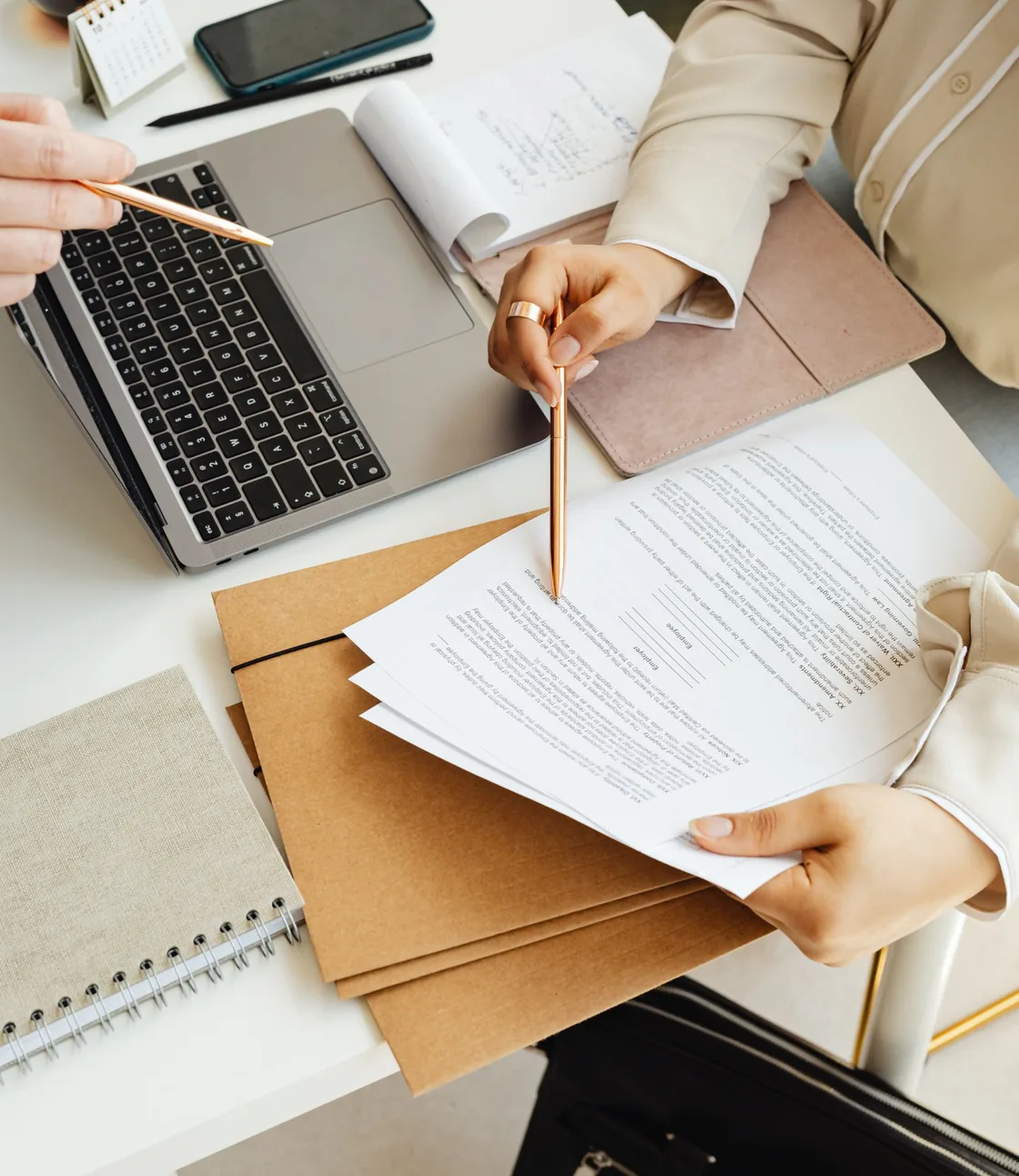 Tax advisers reviewing a client's documents with pen and laptop